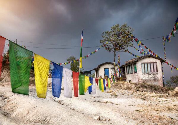 Colorful Tibetan flags near the house at overcast sky in Nagarkot mountains, Nepal